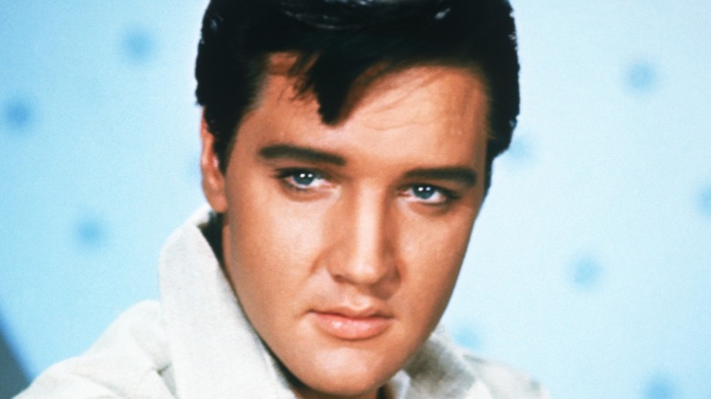 Rock and roll legend Elvis Presley poses for a portrait in a white jacket
