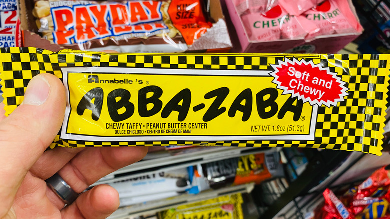 Someone holding an Abba-Zaba candy bar in a store