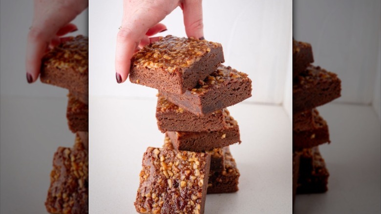 A hand stacks Palmer House brownies atop each other