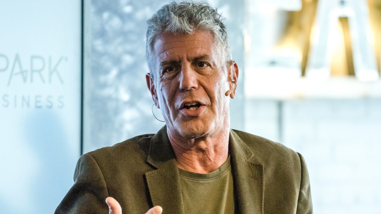 Anthony Bourdain sitting and gesticulating