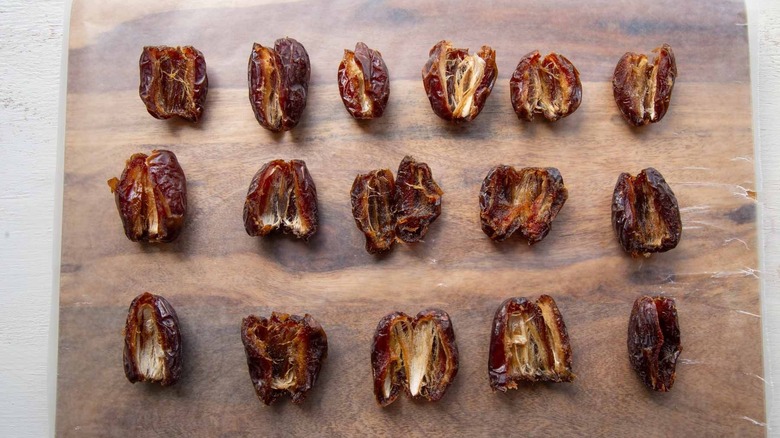 Slightly opened Medjool dates on cutting board