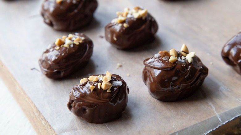 Chocolate covered dates topped with nuts and flaky salt