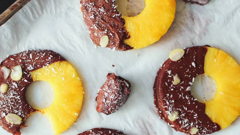 Chocolate-dipped pineapple rings with shaved coconut and almonds
