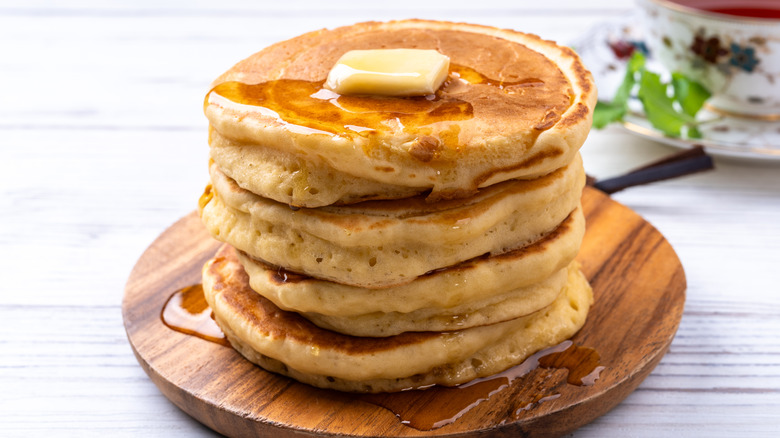 Stack of fluffy pancakes with syrup and butter
