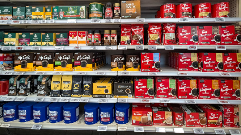 Various brands of coffee on grocery store shelf