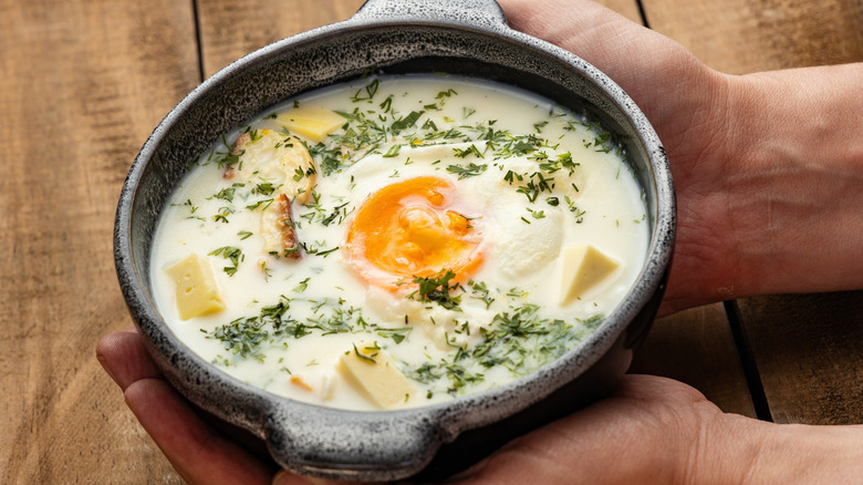 Person holding a bowl of Colombian changua