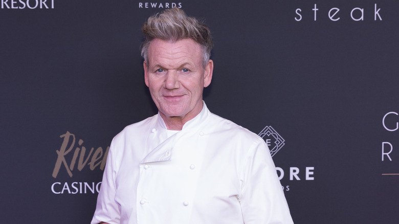 Gordon Ramsay posing in his chef's jacket on a red carpet