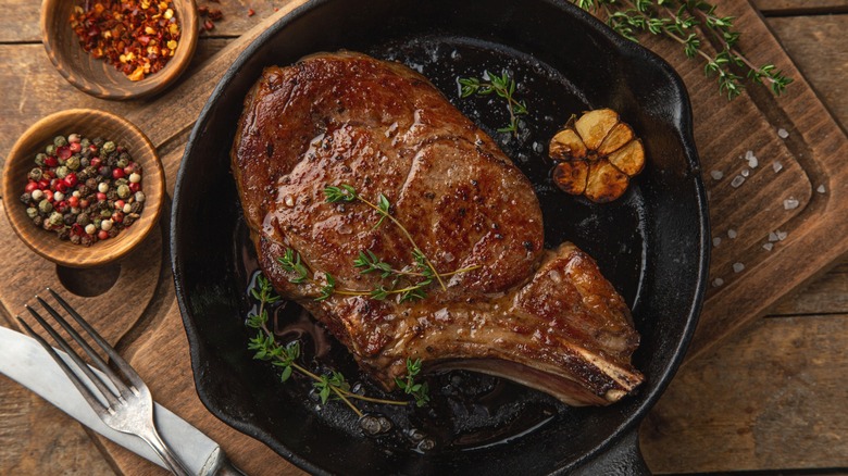 Steak in cast-iron pan with garlic and herbs