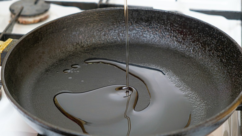 Oil poured into cast-iron pan close up