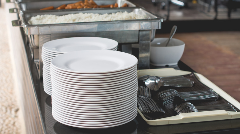 Clean plates and silverware at a buffet