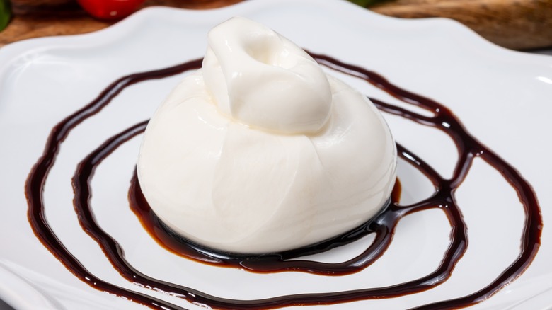 fresh mozzarella on a white plate decorated with balsamic vinegar