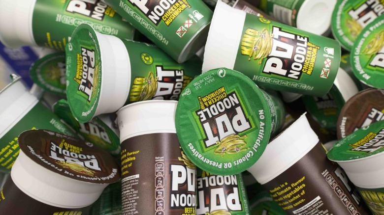 A number of Pot Noodle containers in a big pile.