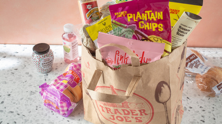 A paper Trader Joe's shopping bag full of snacks