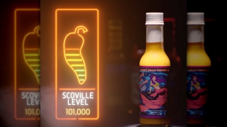A bottle of Angry Goat Pepper Co. Dreams of Calypso Hot Sauce next to the Hot Ones Scoville scale.