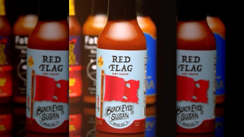 A bottle of Black Eyes Susan's Red Flag Hot Sauce.