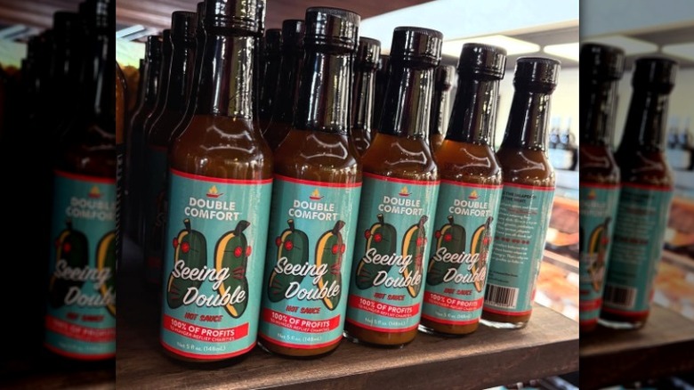 Bottles of Double Comfort Seeing Double Hot Sauce on a shelf.