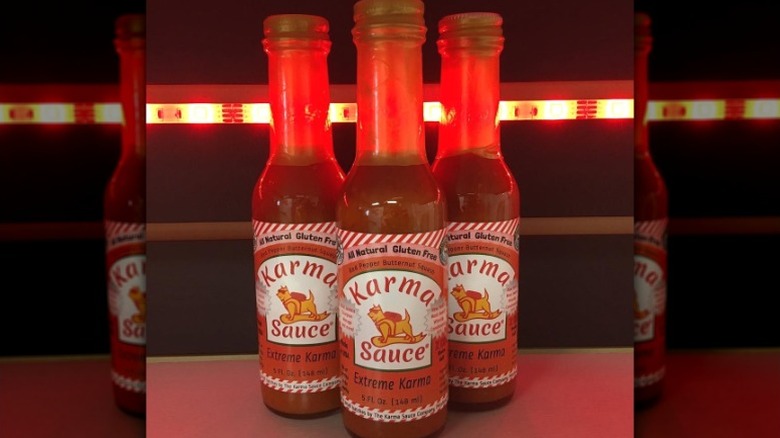 Three bottles of Extreme Karma Sauce.