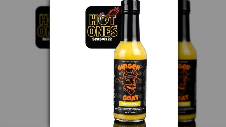 A bottle of Ginger Goat Tropic Star Hot Sauce, with the "Hot Ones" logo behind it.