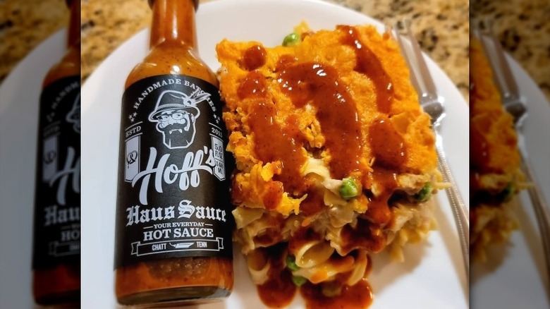 A bottle of Hoff & Pepper Hoff's Haus Sauce next to tuna casserole.