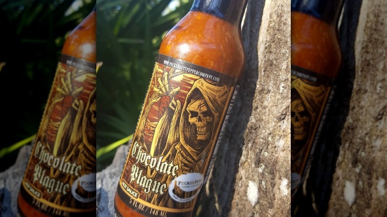 A bottle of Puckerbutt Chocolate Plague hot sauce.
