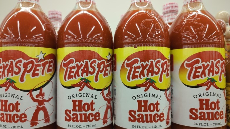 Bottles of Texas Pete hot sauce on a supermarket shelf.