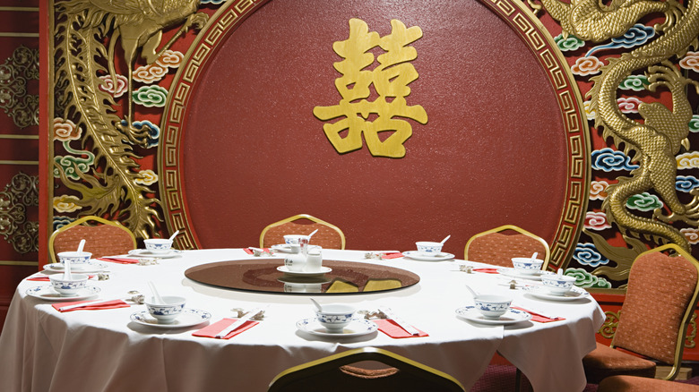 A large table set at an ornately decorated Chinese restaurant