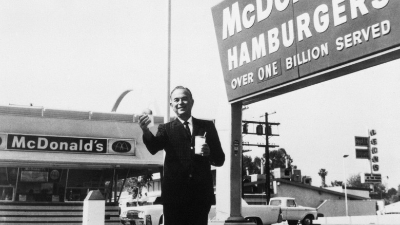 Ray Kroc at a franchised McDonald's holding food in early 1960s in black and white photograph