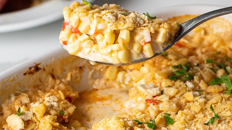 spoonful of scalloped corn with peppers and onions