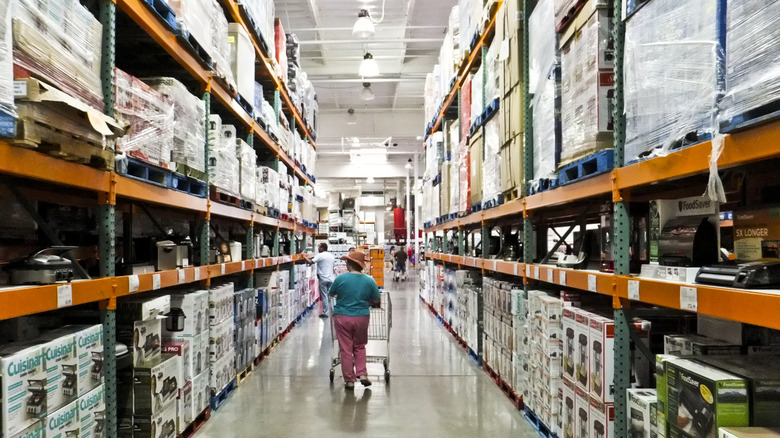 Shopper pushing cart in Costco warehouse aisle