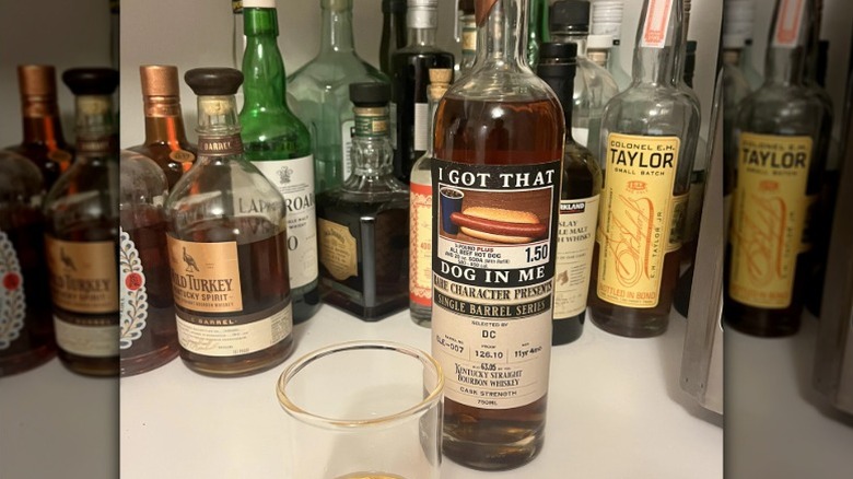 A bottle of Costco hot dog combo themed bourbon on a whiskey shelf.