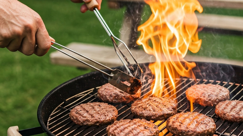 juicy burger patties being cooked on open grill