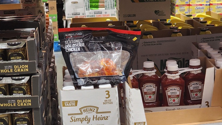 A Kirkland Signature Rotisserie Chicken on top of a bundle of ketchup bottles at Costco