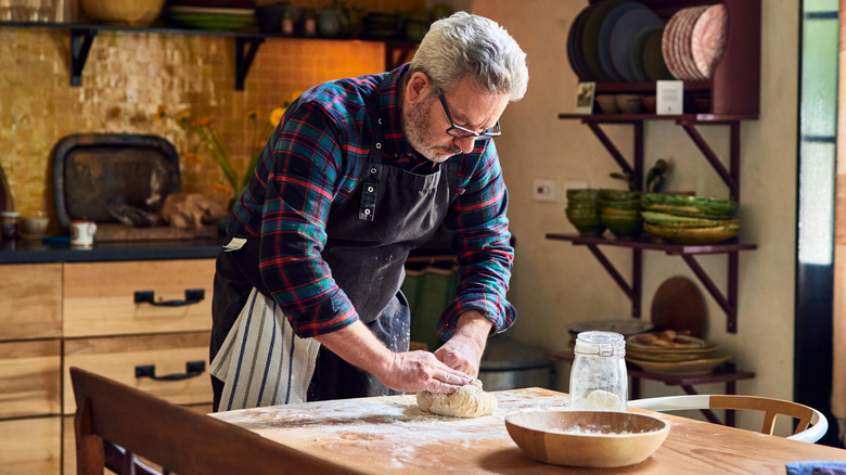 A home baker kneads bread dough
