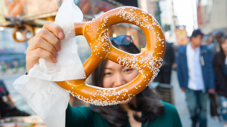 person holding a giant pretzel