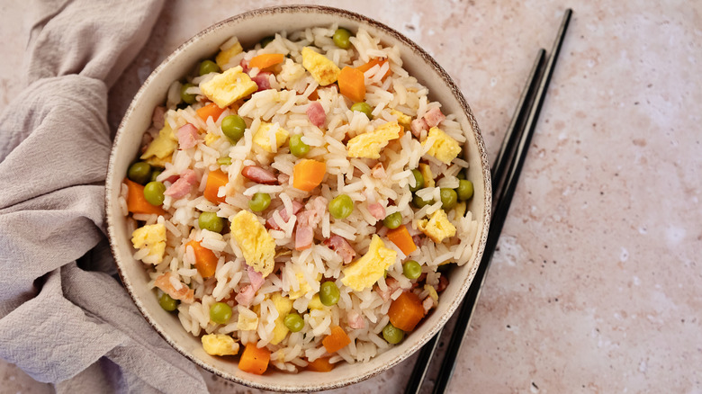 Bowl of fried rice with egg, peas, carrots, and ham