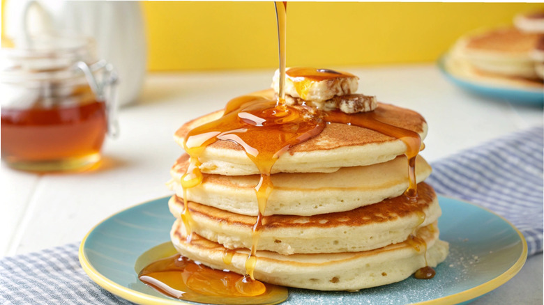 A stack of pancakes dripping with syrup