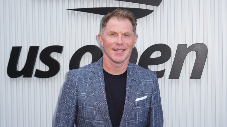 Bobby Flay smiling for the cameras while attending the US Open Tennis Championship at the USTA Billie Jean King National Tennis Center on September 04, 2025 in New York City.