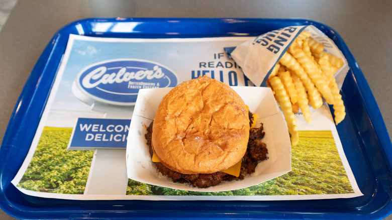 A ButterBurger with fries on the side on a blue tray inside a Culver's restaurant.