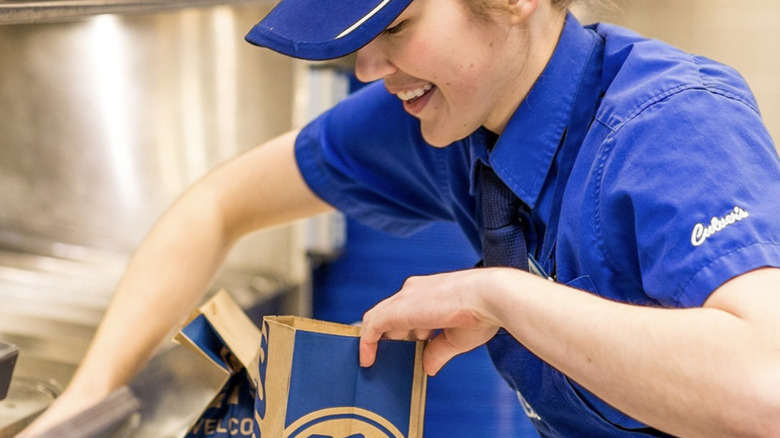 A Culver's employee packs an order in a takeout bag