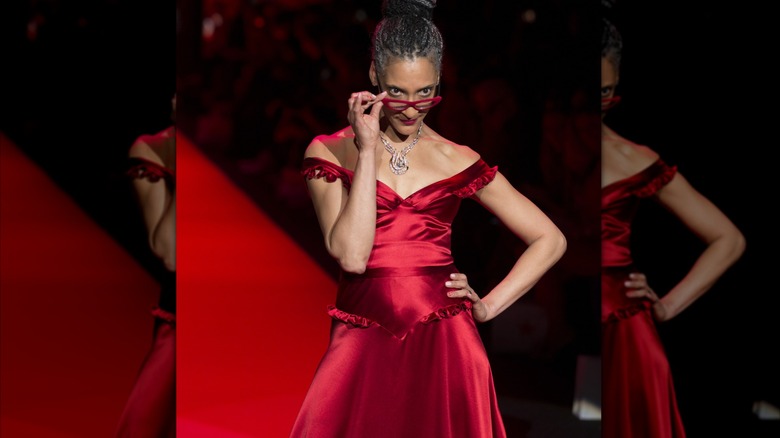 Carla Hall posing on runway in red dress