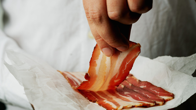 Chef pulling apart strips of bacon