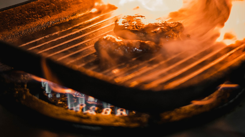 Pieces of meat burning up as a result of a grill flare-up