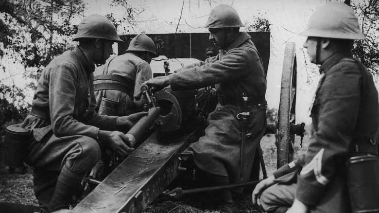 French soldiers load up a 75mm field gun in WWI