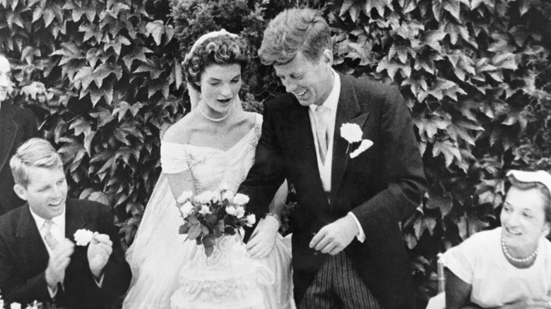 John F. Kennedy and Jacqueline Kennedy cutting their wedding cake at their wedding.