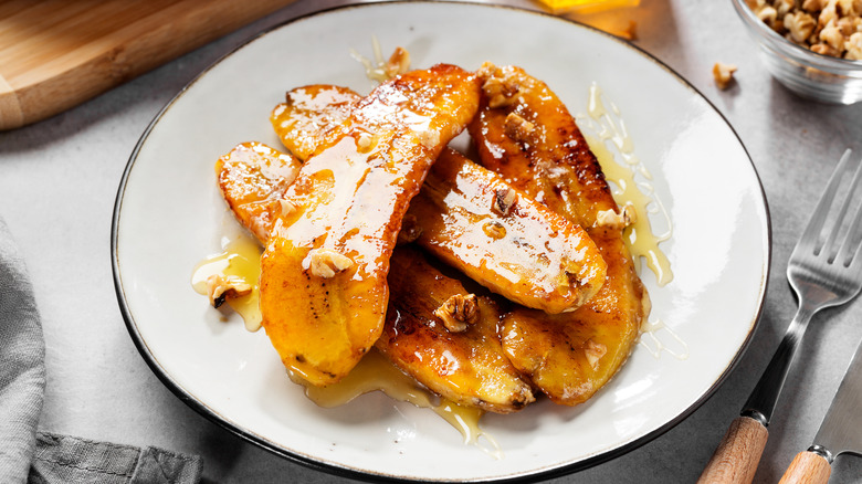 A pile of sliced caramelized bananas with syrup and nuts