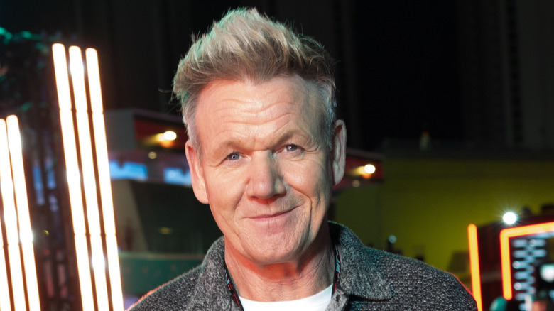 Gordon Ramsay smiling outside wearing a sweater.
