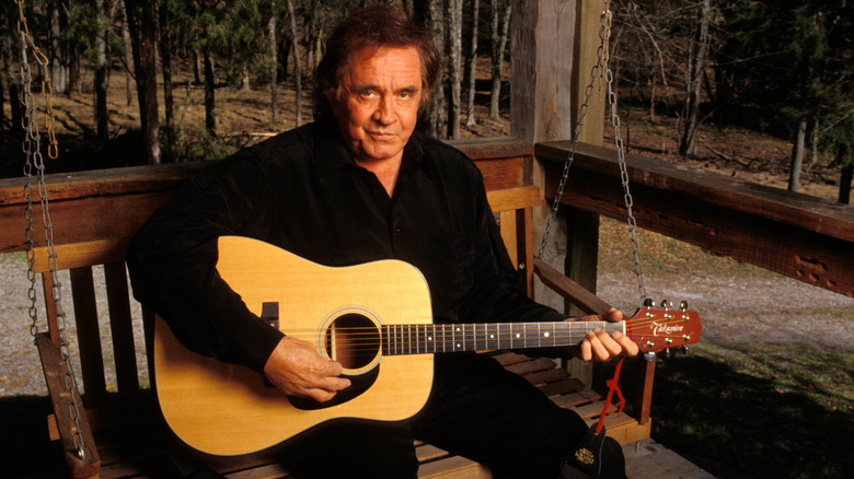 johnny cash with guitar sitting on porch swing