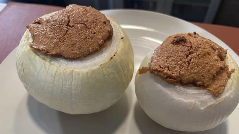 Two baked peanut butter stuffed onions on a plate