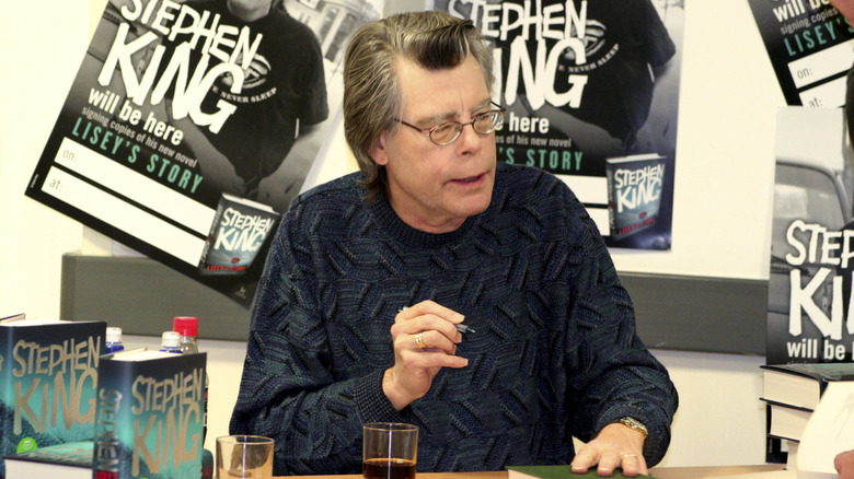 Stephen King at a book signing with a cup of coffee