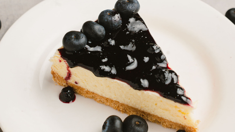 A closeup of a slice of blueberry cheesecake on a plate
